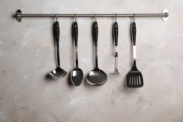 Bastidor con utensilios de cocina limpios en la pared de color — Foto de Stock