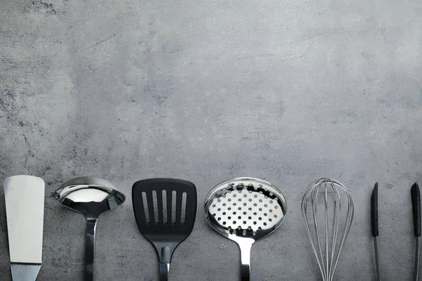 Set of clean kitchen utensils on grey background, flat lay. Space for text — Stock Photo, Image