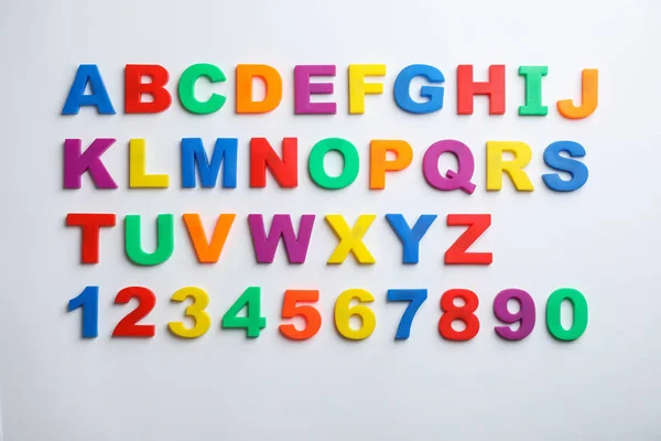 Magnetbuchstaben und Zahlen aus Kunststoff isoliert auf weiß, Ansicht von oben — Stockfoto