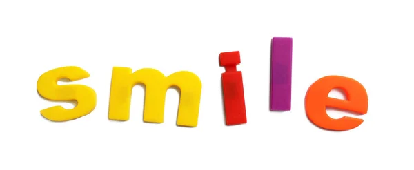 Palavra SMILE de letras magnéticas sobre fundo branco, vista superior — Fotografia de Stock