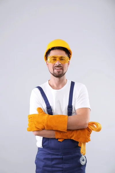 Trabalhador industrial masculino em uniforme no fundo claro. Equipamento de segurança — Fotografia de Stock