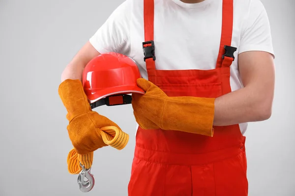 Mannelijke industriële werknemer in uniform op lichte achtergrond, close-up. Veiligheidsuitrusting — Stockfoto