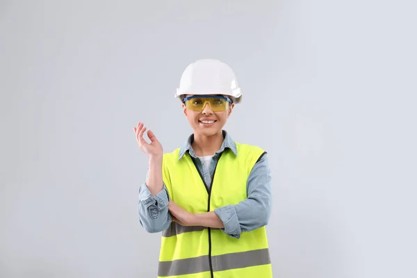 Wirtschaftsingenieurin in Uniform auf hellem Hintergrund. Sicherheitsausrüstung — Stockfoto