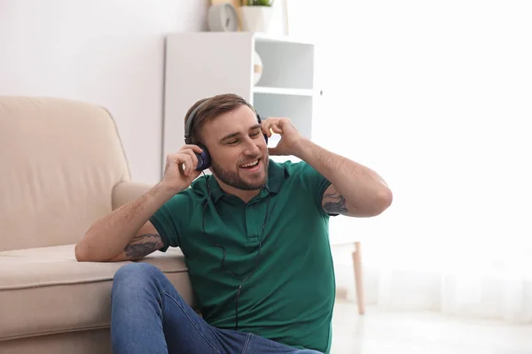 Joven con auriculares disfrutando de la música en casa —  Fotos de Stock