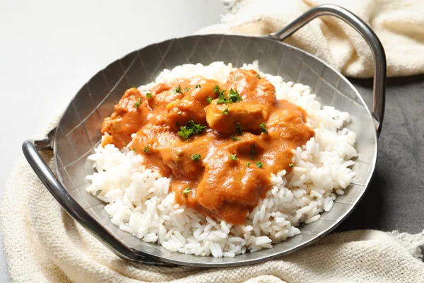 Delicioso frango manteiga com arroz em prato e guardanapo na mesa — Fotografia de Stock