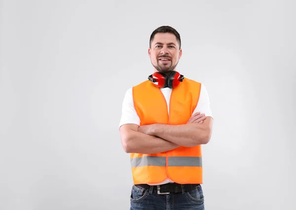 Engenheiro industrial masculino em uniforme no fundo claro. Equipamento de segurança — Fotografia de Stock