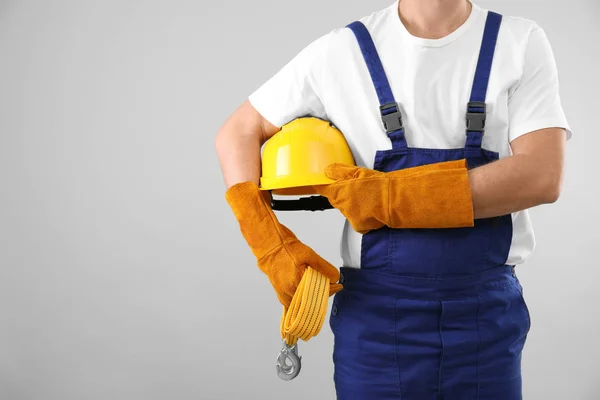 Αρσενικό βιομηχανικός εργάτης στη στολή σε ανοιχτόχρωμο φόντο, closeup με χώρο για κείμενο. Εξοπλισμός ασφαλείας — Φωτογραφία Αρχείου