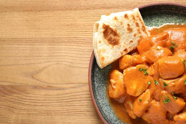 Delicious butter chicken on wooden table, top view with space for text. Traditional Murgh Makhani dish — Stock Photo, Image