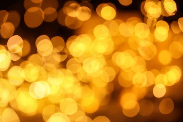 Gold glitter with bokeh effect on dark background