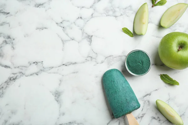 Composición plana con deliciosa paleta de espirulina sobre mesa de mármol. Espacio para texto — Foto de Stock