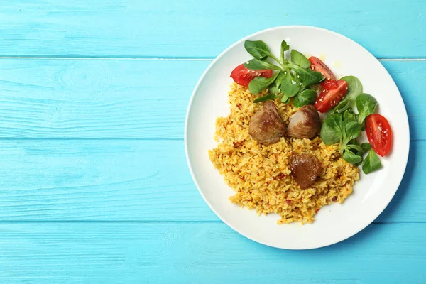 Piatto di delizioso riso pilaf e insalata su sfondo di legno, vista dall'alto con spazio per il testo — Foto Stock