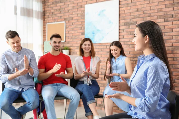 Grupo de jóvenes que aprenden el lenguaje de señas con el profesor en interiores — Foto de Stock