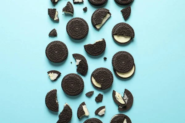 Sabrosas galletas de chocolate con crema en el fondo de color, la puesta plana — Foto de Stock