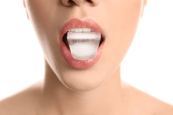 Giovane donna con cubo di ghiaccio in bocca su sfondo bianco, primo piano — Foto Stock