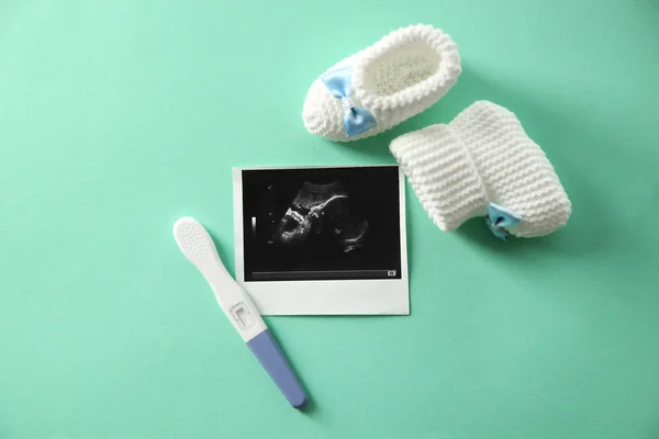 Imagem de ultra-som, sapatos de bebê e teste de gravidez no fundo de cor, vista superior — Fotografia de Stock