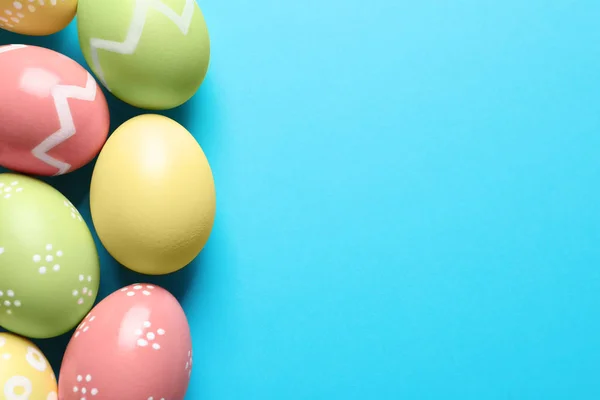 Belos ovos de Páscoa pintados sobre fundo de cor, flat lay. Espaço para texto — Fotografia de Stock