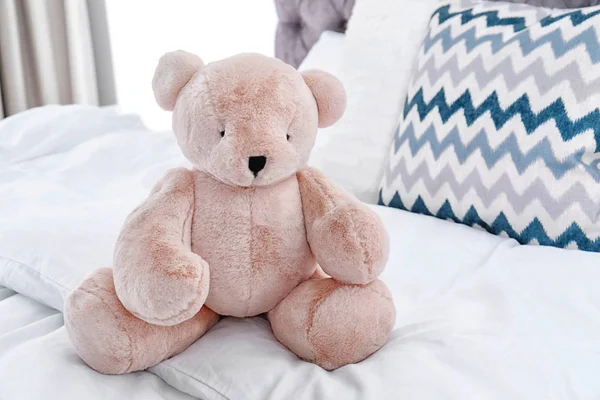 Cute teddy bear sitting on bed indoors. Space for text — Stock Photo, Image