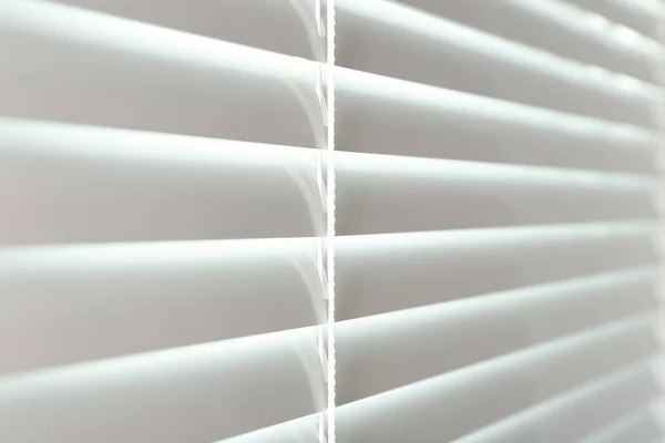 Closed modern white window blinds, closeup view