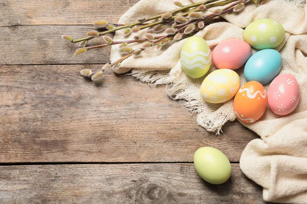 Composición de la puesta plana con coloridos huevos de Pascua pintados en mesa de madera, espacio para el texto —  Fotos de Stock