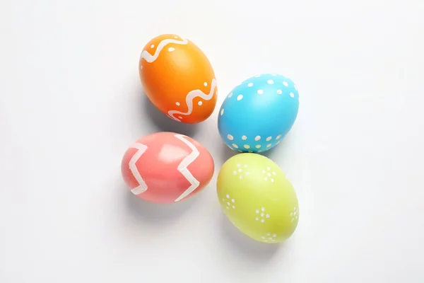 Krásná malovaná velikonoční vajíčka na bílém pozadí, pohled shora — Stock fotografie