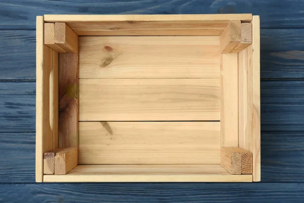 Empty wooden crate on color background, top view