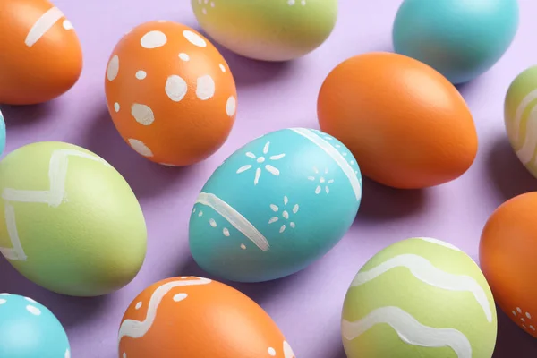 Πολλά όμορφα βαμμένα πασχαλινά αυγά σε έγχρωμο φόντο, κοντινό πλάνο — Φωτογραφία Αρχείου