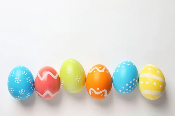 Krásná malovaná velikonoční vajíčka na bílém pozadí, pohled shora — Stock fotografie