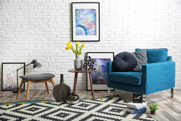 Salon intérieur moderne avec fauteuil confortable et tabouret près du mur de briques — Photo