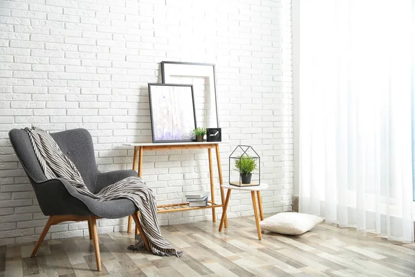 Elegante salón interior con cómodo sillón cerca de la pared de ladrillo. Espacio para texto —  Fotos de Stock