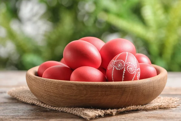 배경 흐리게 테이블에 그려진된 빨간색 부활절 달걀 나무 그릇 — 스톡 사진