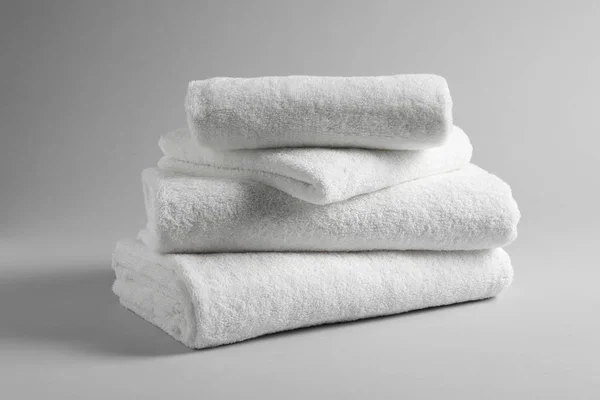 Stack of fresh towels on light background — Stock Photo, Image