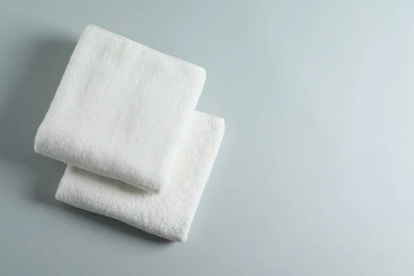 Soft folded towels on light background, top view with space for text — Stock Photo, Image