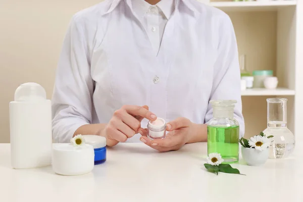 Dermatóloga hembra probando productos para el cuidado de la piel en la mesa, primer plano — Foto de Stock