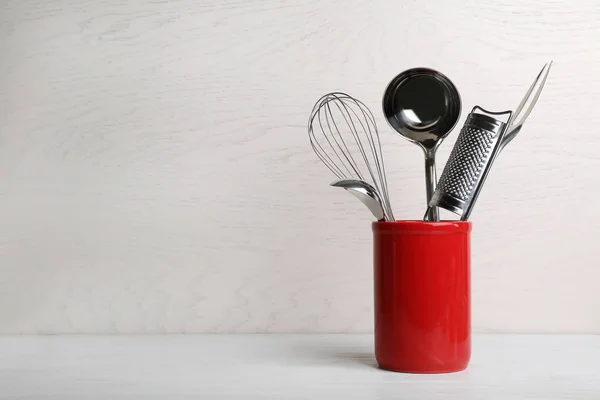 Soporte con utensilios de cocina limpios en la mesa. Espacio para texto — Foto de Stock