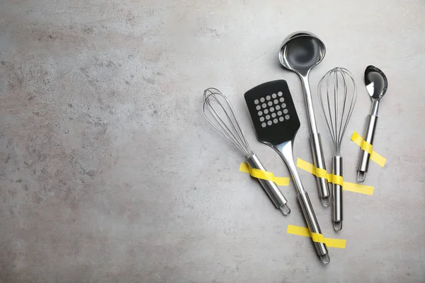 Set de utensilios de cocina limpios sobre fondo gris, plano. Espacio para texto — Foto de Stock