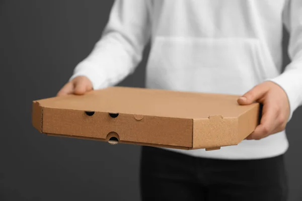 Young woman with pizza box on grey background, closeup. Food delivery service — Stock Photo, Image