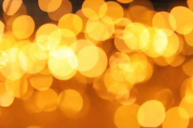 Koyu arka plan üzerinde bokeh etkisi ile altın glitter