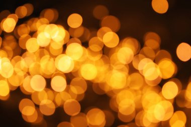 Koyu arka plan üzerinde bokeh etkisi ile altın glitter