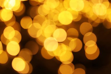 Koyu arka plan üzerinde bokeh etkisi ile altın glitter