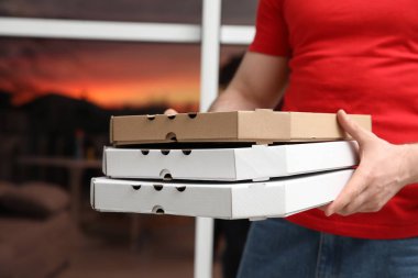 Kurye ile pizza kutuları arka plan bulanık, closeup üzerinde