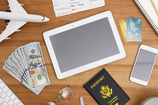Plochá laických složení s modelem letadla a tablet na dřevěný stůl v cestovní kanceláři — Stock fotografie