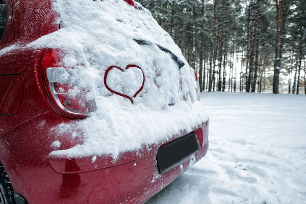 Coração desenhando em neve carro coberto na floresta de inverno. Espaço para texto — Fotografia de Stock