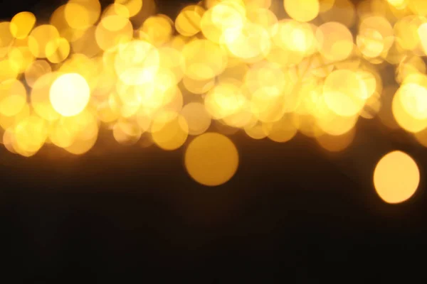 Brilho de ouro com efeito bokeh no fundo escuro — Fotografia de Stock