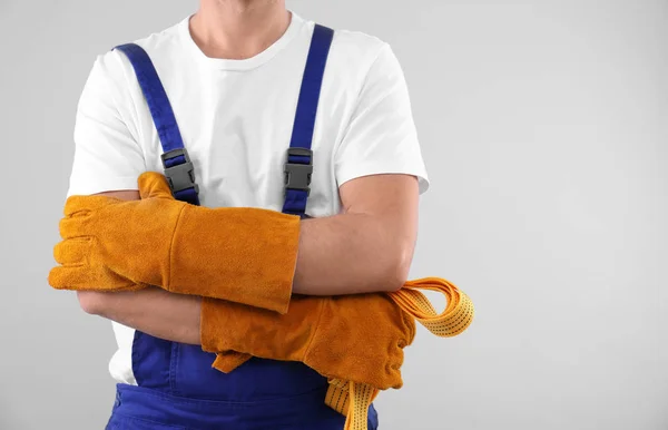 Αρσενικό βιομηχανικός εργάτης στη στολή σε ανοιχτόχρωμο φόντο, closeup με χώρο για κείμενο. Εξοπλισμός ασφαλείας — Φωτογραφία Αρχείου