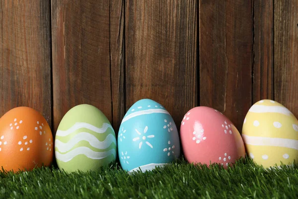 五颜六色的彩绘复活节彩蛋在绿草对木背景, 文本空间 — 图库照片