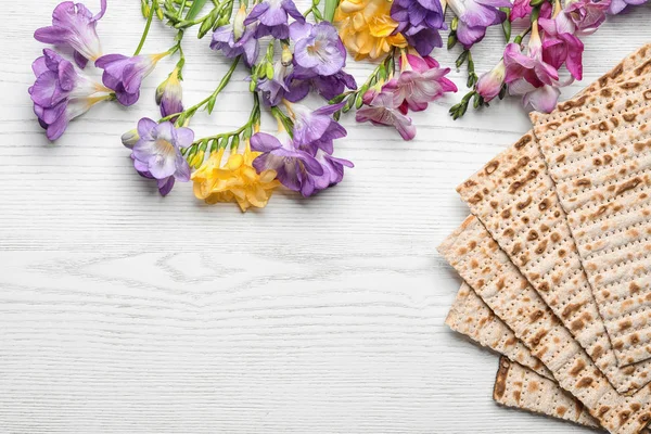 Flat lay composition of matzo and flowers on wooden background, space for text. Passover (Pesach) Seder — Stock Photo, Image