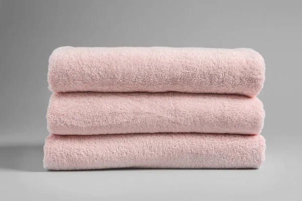 Pilha de toalhas frescas no fundo claro — Fotografia de Stock