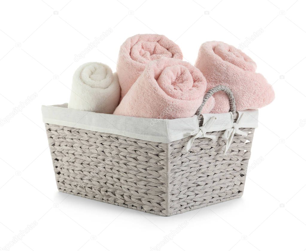Rolled soft towels in basket on white background