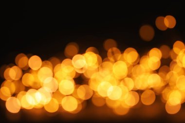 Koyu arka plan üzerinde bokeh etkisi ile altın glitter