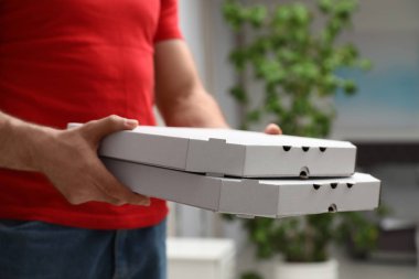 Kurye ile pizza kutuları arka plan bulanık, closeup üzerinde